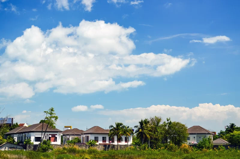 White cottages under blue sky with palm trees