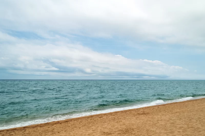 Сцена прибрежного пляжа с облачным небом