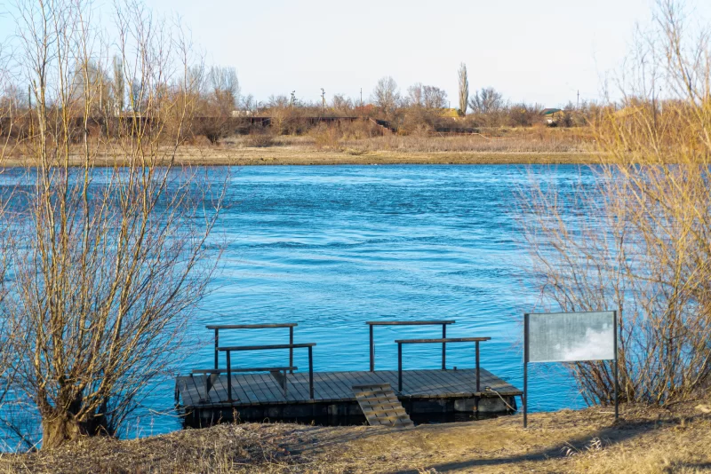 Деревянная пристань на реке с голыми деревьями