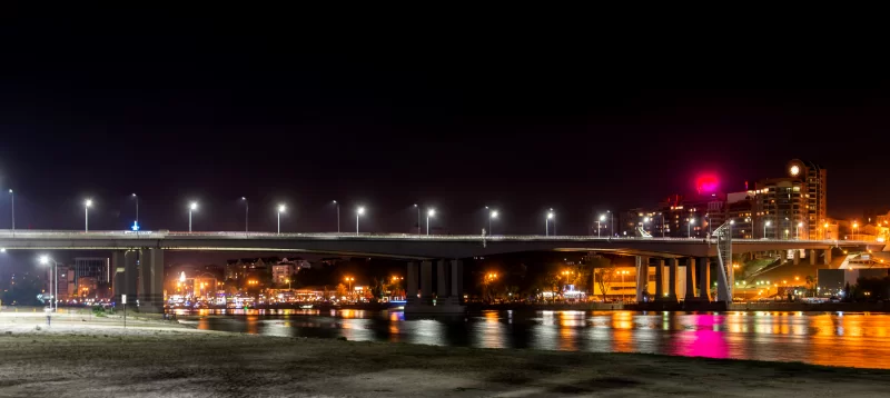 Night Bridge Over River With City Lights