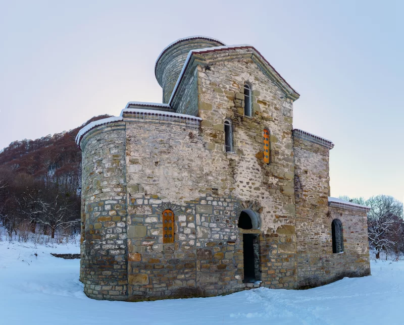 Древний заброшенный православный храм в заснеженном зимнем пейзаже Северного Кавказа