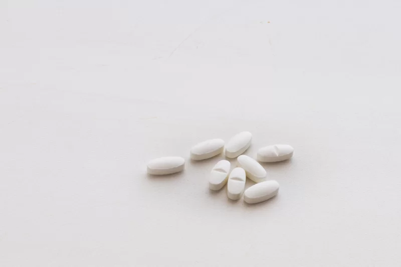 Белые овальные таблетки на светлом фоне