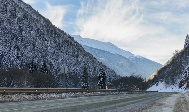 Зимняя дорога в заснеженных горах