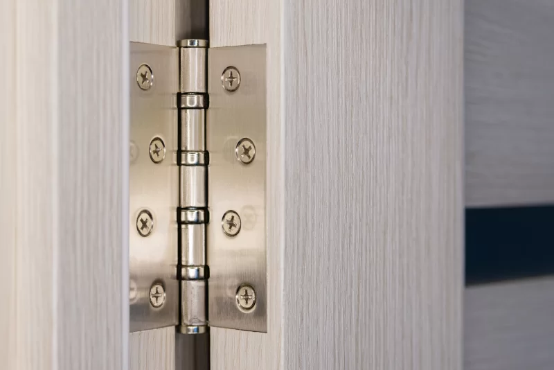 Детальный макроснимок металлических петель двери с деревянной текстурой