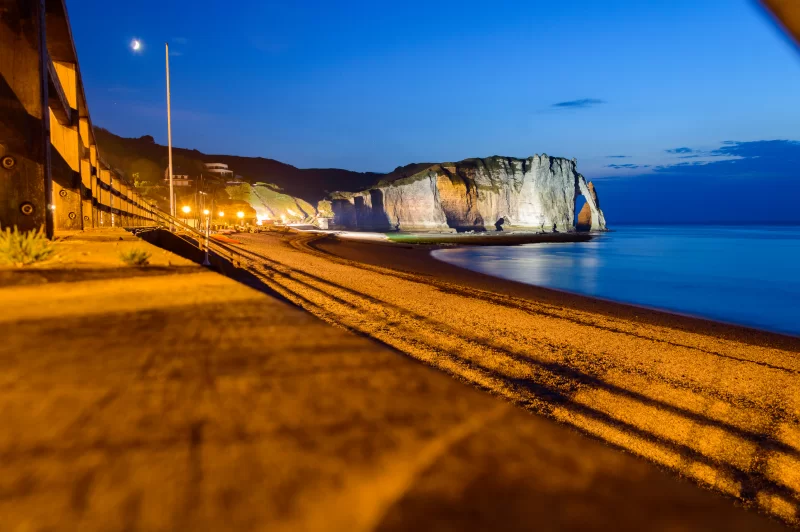 Вечерний вид на знаменитую арку в Этрета, Франция, освещенную ночными огнями