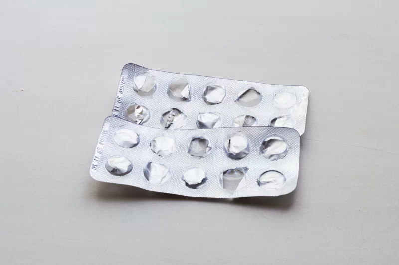 Empty blister packs of pills on a gray background
