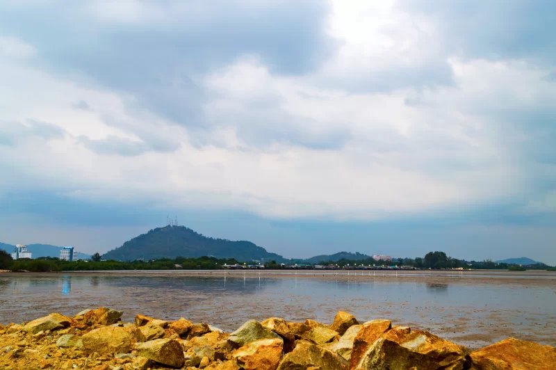 Пейзаж прибрежной зоны с каменистым берегом и видом на гору