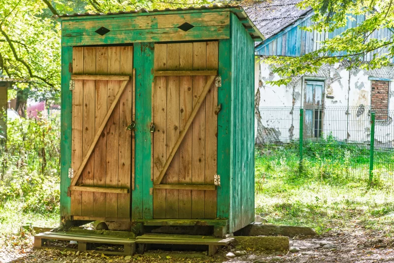 Старый деревянный сарай с зелёной краской в сельской местности