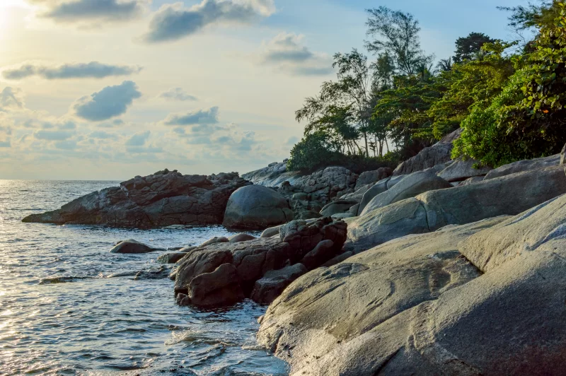 Golden sunrise over rocky coastline