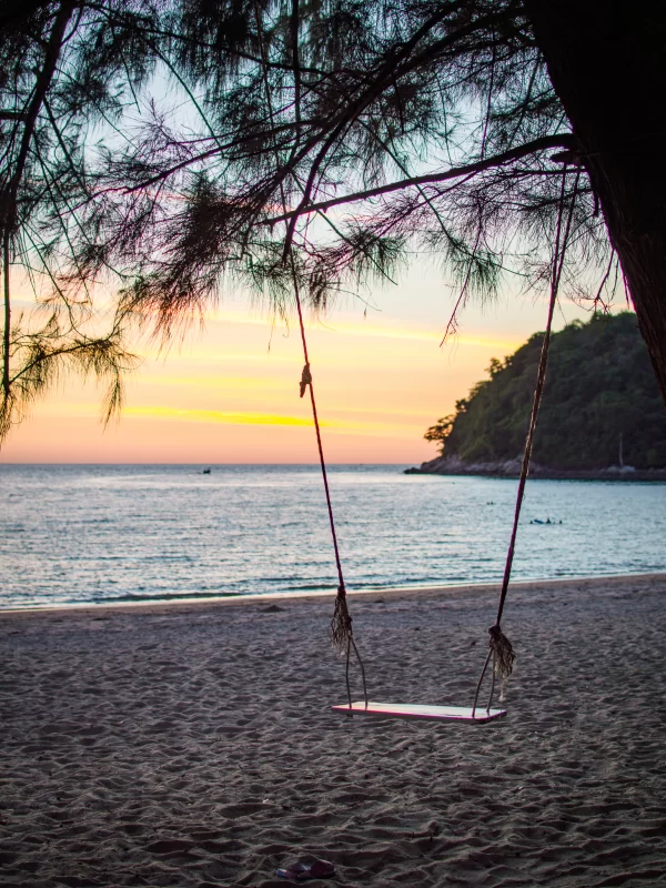 Качели на тропическом пляже на закате