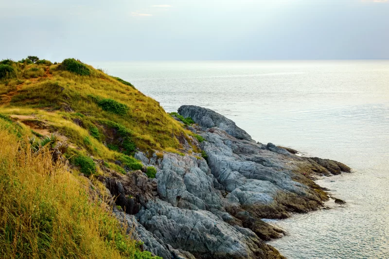 Крутой скалистый берег с зеленью и спокойным морем