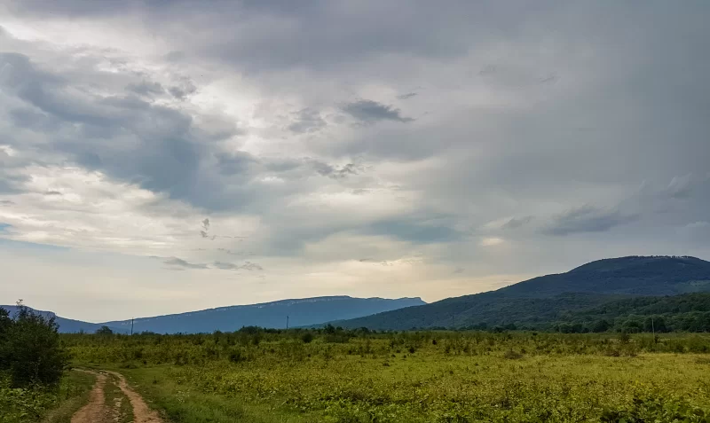 Величественный горный пейзаж с облаками и тропой