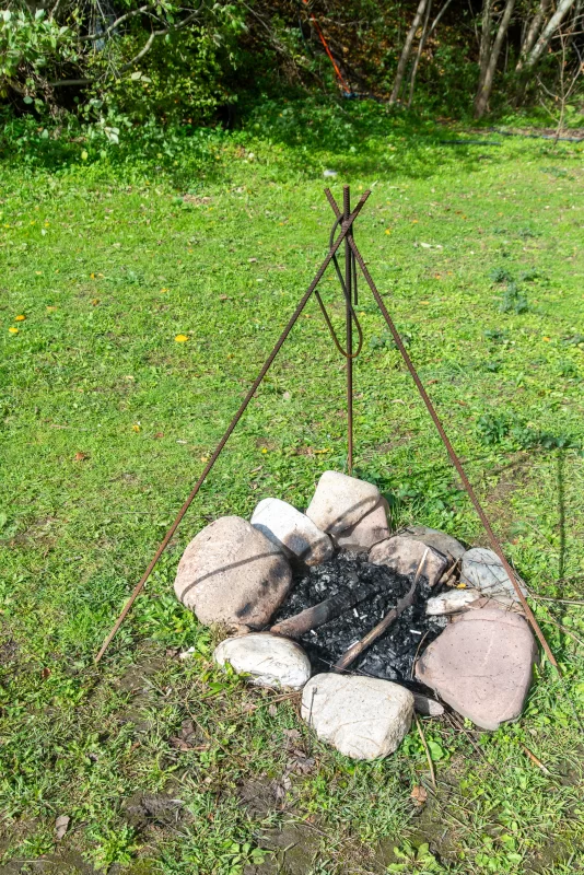 Костёр в саду: готовый к ужину, с металлической подставкой и зелёной травой