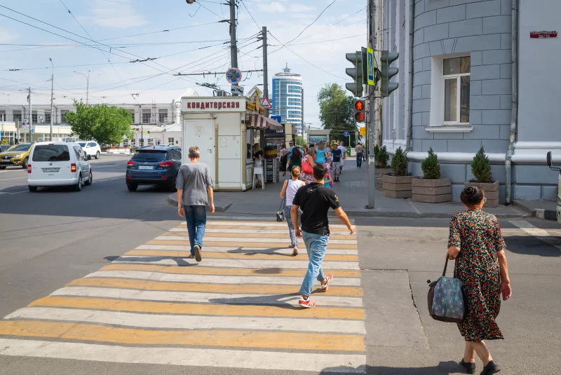 Pedestrians jaywalk, crossing the road on a red traffic light