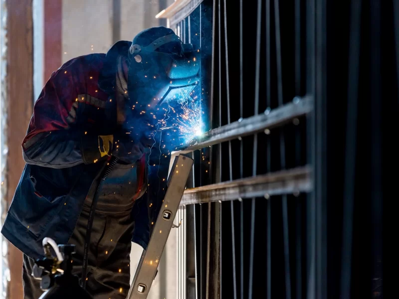 Сварщик работает над металлической конструкцией