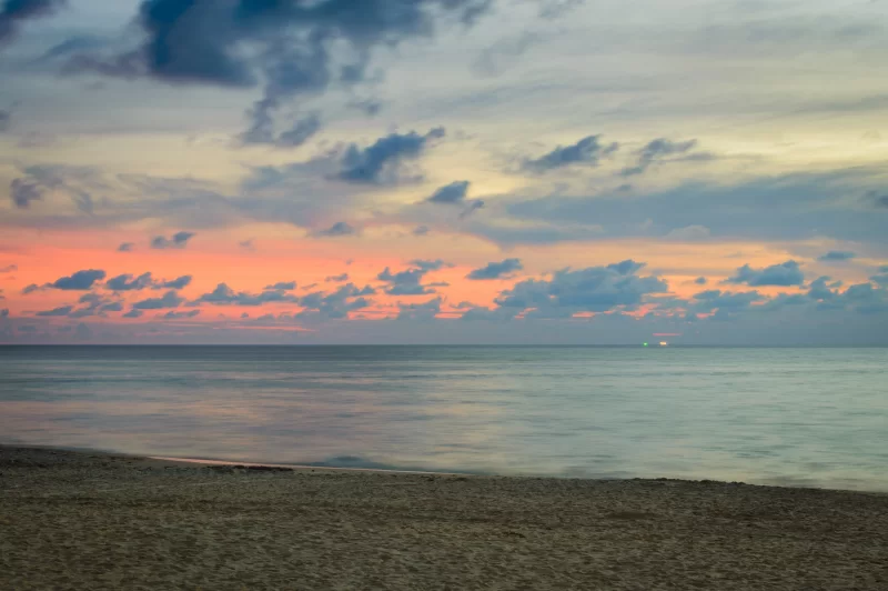 Золотой рассвет над спокойным океаном и пляжем