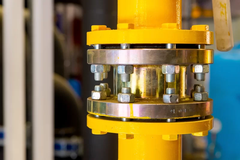 Крупный план фланцевого соединения трубопровода с яркой желтой окраской