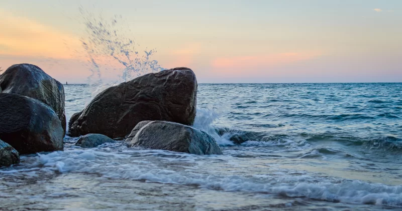 Wave Splash Against Rocks at Sunset