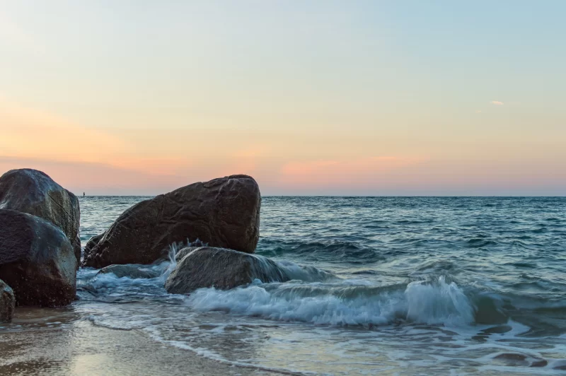 Волны океана разбиваются об скалы на закате
