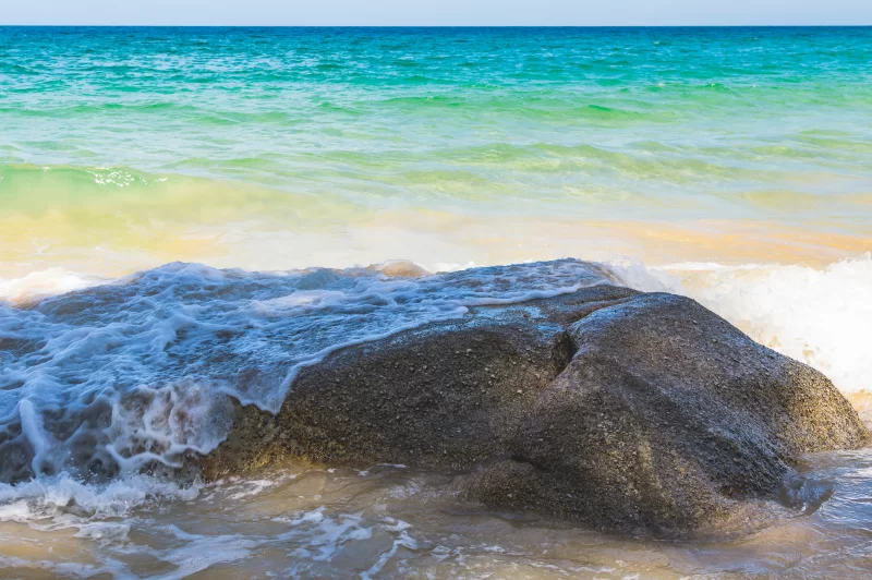 Тропический пляж: волны бьются о скалы