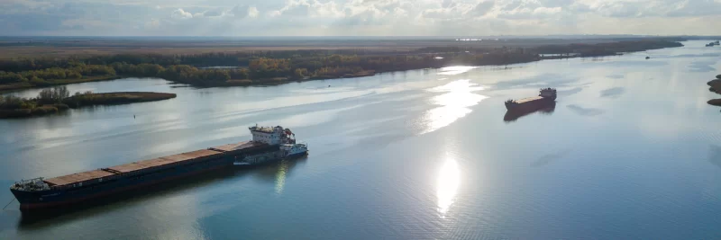 Речной пейзаж с грузовыми судами на рассвете: спокойствие и движение