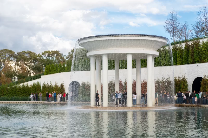 Современный фонтан и люди у водоема