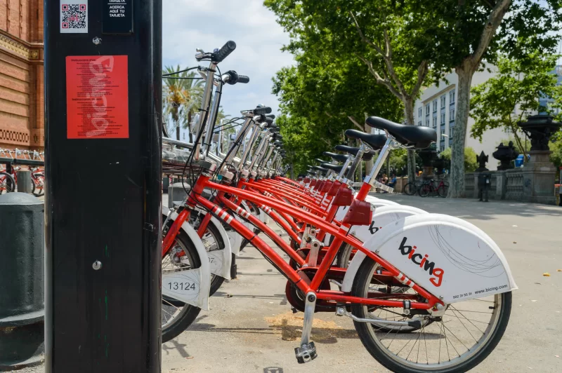 Красные велосипеды для аренды, припаркованные в Барселоне