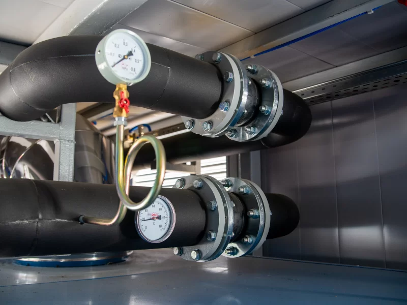 Промышленная система трубопроводов с манометрами в техническом помещении