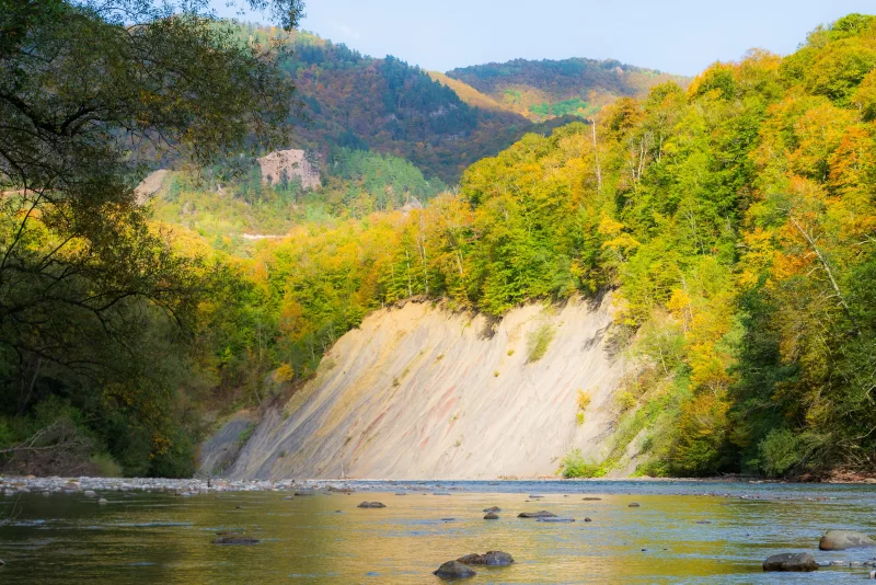 Река в Адыгее осенью с ярким лесом и скальным уступом