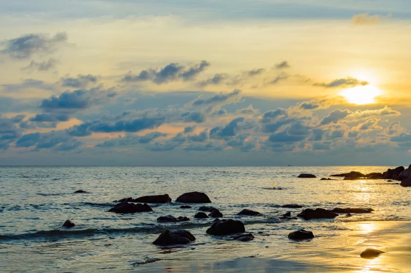Золотой рассвет над океаном с скалистым берегом
