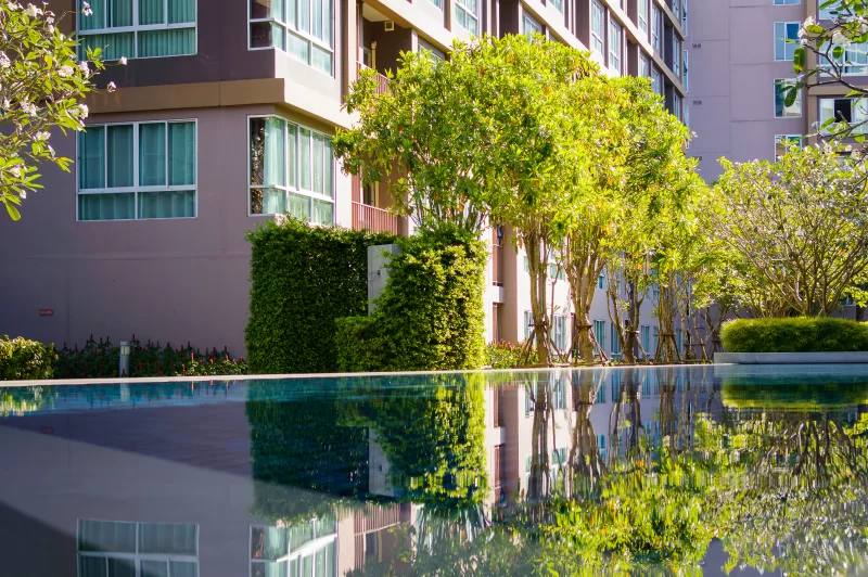 Отражение современного жилого дома в бассейне с эффектом бесконечности