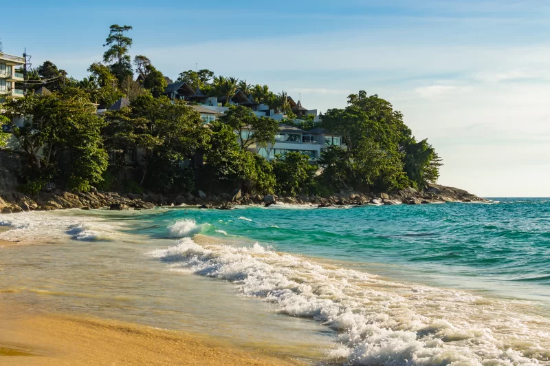 Тропический пляж с бирюзовыми волнами и роскошным отелем