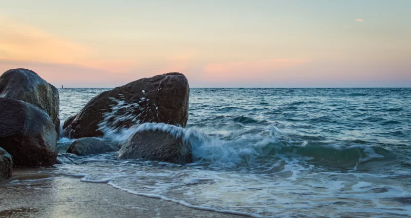 Разбрызгивание волны о камни на закате