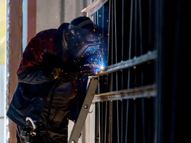 Сварщик работает над металлической конструкцией