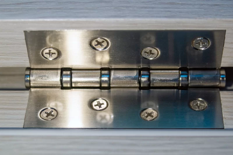 Металлическая петля на деревянной двери: детальный макроснимок