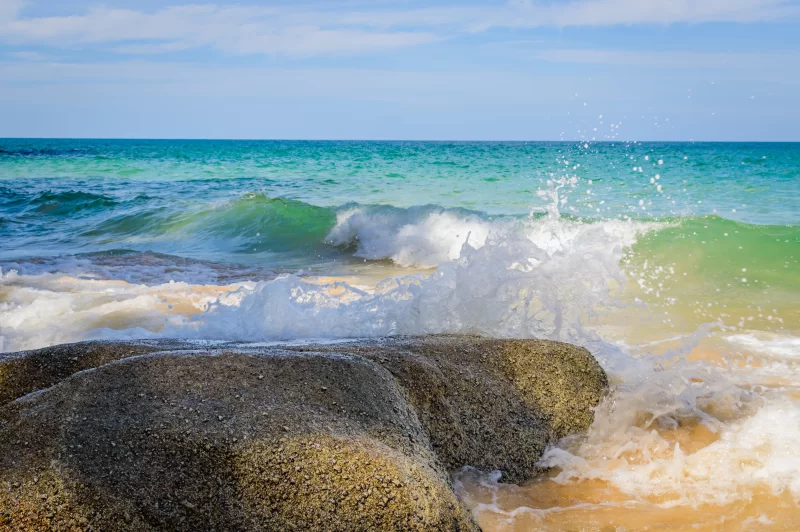 Мощные волны океана разбиваются на скалистом берегу