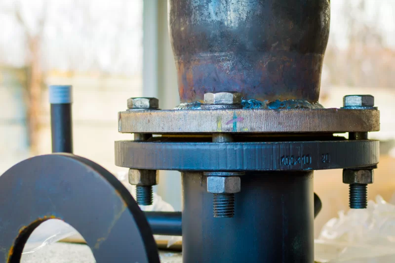 Крупный план фланцевого соединения труб с болтами и гайками