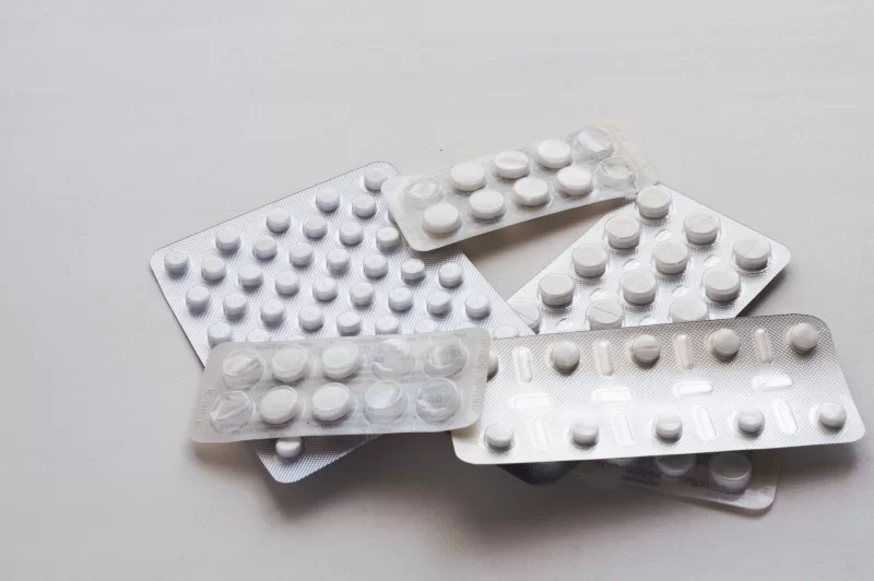 Blister packs with pills and capsules on a light background