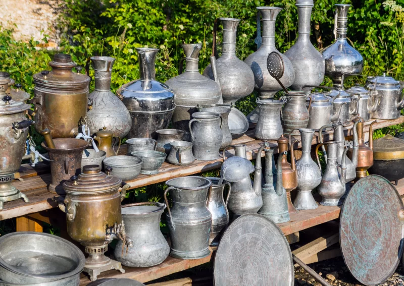Старинные металлические кувшины и посуда на деревянной тележке